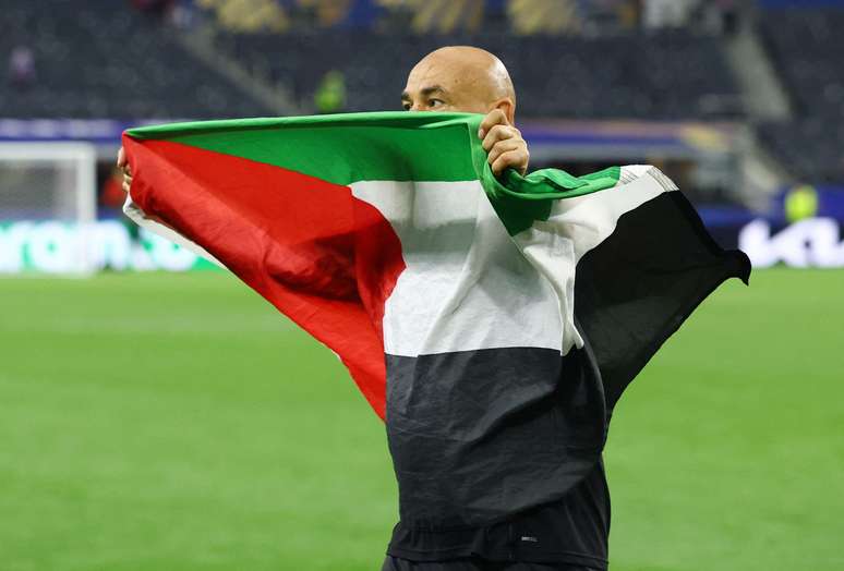 O t&eacute;cnico eg&iacute;pcio Hossam Hassan com a bandeira palestina