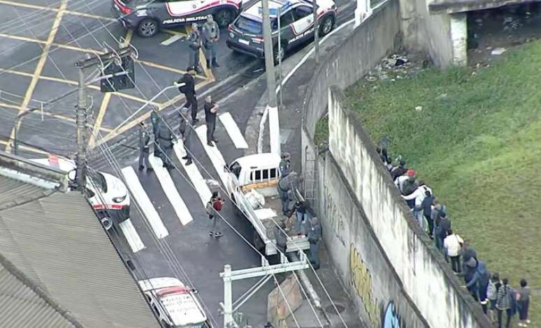 Passageiros subindo em muro, ap&oacute;s falha afetar circula&ccedil;&atilde;o de trens.