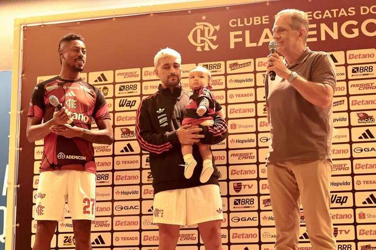 Arrascaeta, com Milano no colo, no an&uacute;ncio oficial de que ganhar&aacute; um busto no Flamengo. Assim como ocorrer&aacute; com Bruno Henrique.