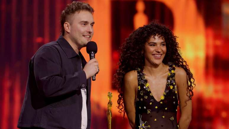 Sam Fender e Olivia Dean recebem o Pr&ecirc;mio BRIT de can&ccedil;&atilde;o do ano por Rein Me In, considerado o 'hino dos evitativos'