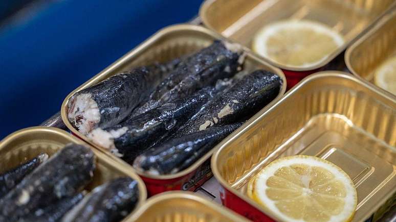 Latas de sardinhas abertas, outras contendo rodelas de lim&atilde;o