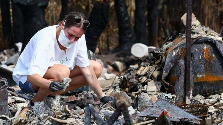 A moradora Julie inspeciona os destro&ccedil;os da casa de seus pais ap&oacute;s ela ter sido destru&iacute;da por um inc&ecirc;ndio florestal em Le Porge