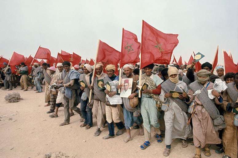 Civis marroquinos carregam bandeiras nacionais, exemplares do Alcor&atilde;o e retratos do rei Hassan 2&ordm; durante a Marcha Verde de novembro de 1975, com a qual Rabat pressionou a Espanha a abandonar o Saara Ocidental