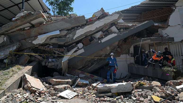 Equipes de resgate buscam sobreviventes entre os escombros de um pr&eacute;dio que desabou em Cali