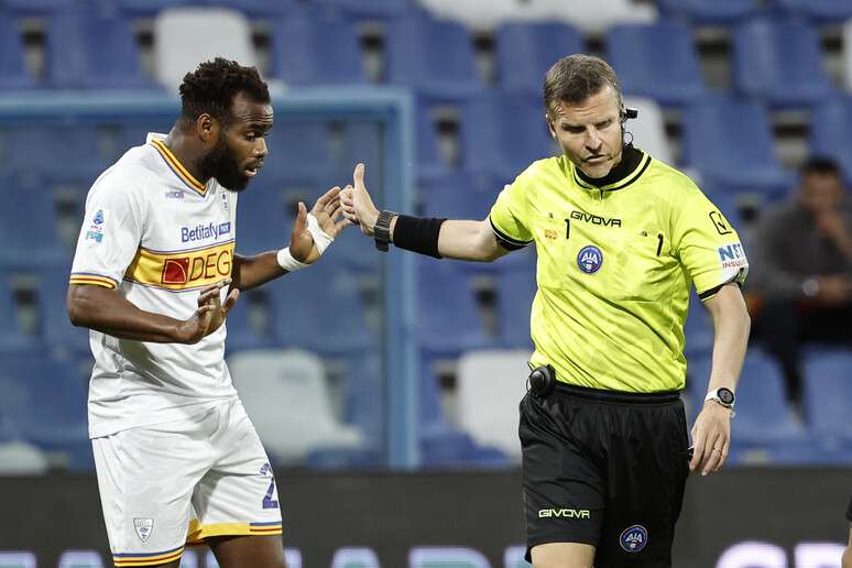 Árbitro Federico La Penna conduz Lassana Coulibaly, do Lecce, para fora de campo em jogo da Série A