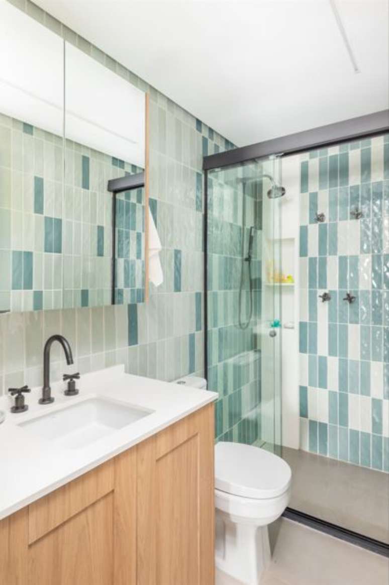 A cuba de embutir harmoniza perfeitamente com a bancada em quartzo branco, mesmo material presente no nicho vertical dentro do box.&nbsp;Projeto BMA Studio&nbsp;|