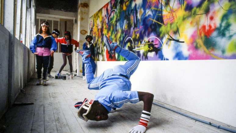 Solo Futura 2000 Renault: Fotografia de Sophie Bramly registra o artista norte-americano Futura 2000 ao lado de um autom&oacute;vel Renault. A imagem remete ao universo do grafite e da arte urbana que marcou a trajet&oacute;ria do artista, um dos nomes mais influentes da cena nova-iorquina surgida nas ruas e no metr&ocirc; da cidade nas d&eacute;cadas de 1970 e 1980.