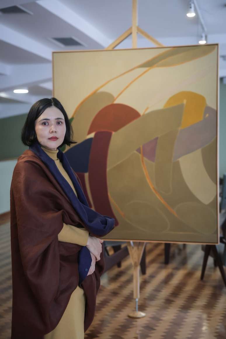 Lu&iacute;sa Matsushita ao lado de uma das obras expostas em 'Tudo que Eu Sei, Eu Aprendi &agrave; Noite'.