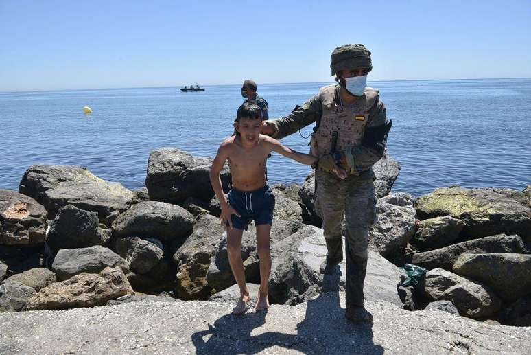 N&atilde;o &eacute; a primeira vez que dezenas de pessoas procedentes do Marrocos tentam chegar a Ceuta a nado. Nesta imagem de 2021, um soldado espanhol auxilia uma crian&ccedil;a estrangeira que acaba de chegar a Ceuta nadando