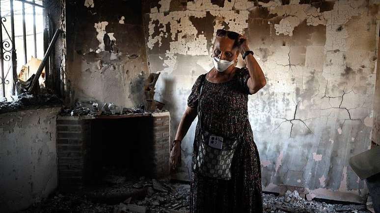 Mulher inspeciona o que restou de sua casa em Navas del Rey, a 55 km a sudoeste de Madri, ap&oacute;s os devastadores inc&ecirc;ndios de julho na Espanha