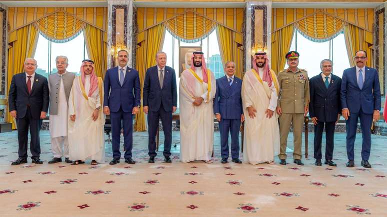 L&iacute;deres e outras figuras pol&iacute;ticas da Turquia, Ar&aacute;bia Saudita e Paquist&atilde;o posam para fotografia, vestindo uma mescla de roupas brancas sauditas, ternos ocidentais, uniformes militares e t&uacute;nicas paquistanesas