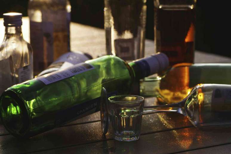 Conjunto de garrafas de bebida alco&oacute;lica e copos vazios