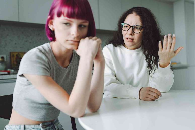 M&atilde;e solteira que trabalha e sua filha adolescente conversam com muita emo&ccedil;&atilde;o na cozinha.