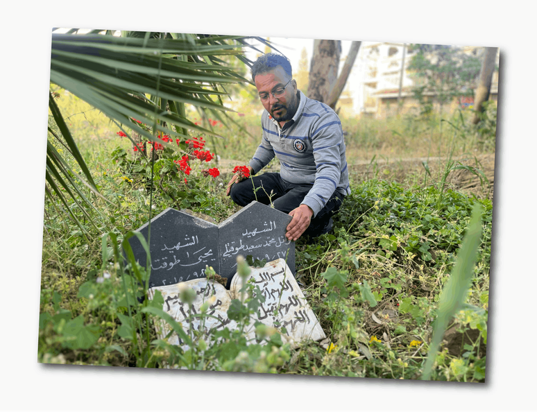 Mohammed Towakatli no t&uacute;mulo do seu filho, morto por um bombardeio em Homs, na S&iacute;ria