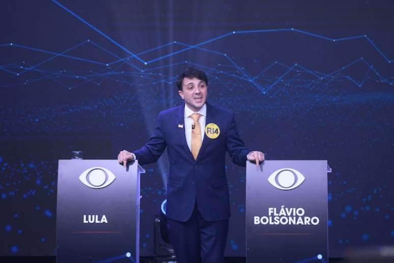 Candidato Renan Santos entre os p&uacute;lpitos vazios de Lula e Fl&aacute;vio Bolsonaro, durante o debate na Band.