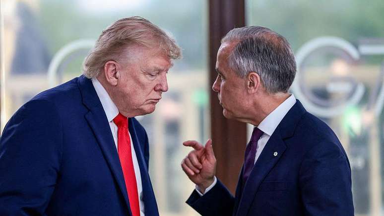 O presidente Donald Trump fala com o primeiro-ministro canadense Mark Carney durante evento do G7