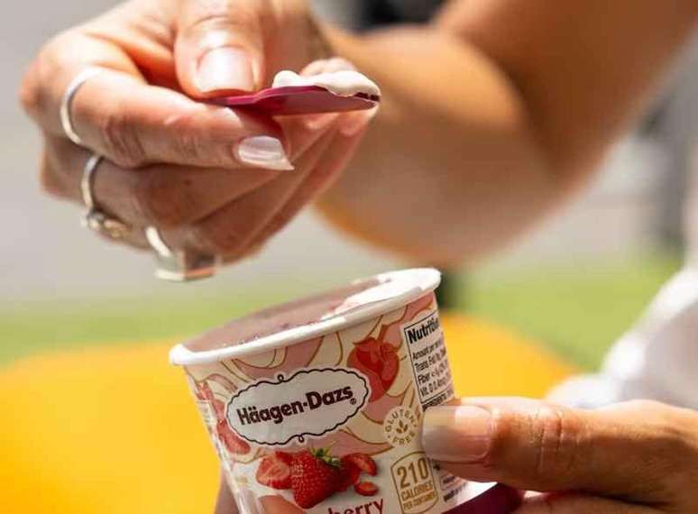 sorvete de morango pequeno da marca em m&atilde;os femininas