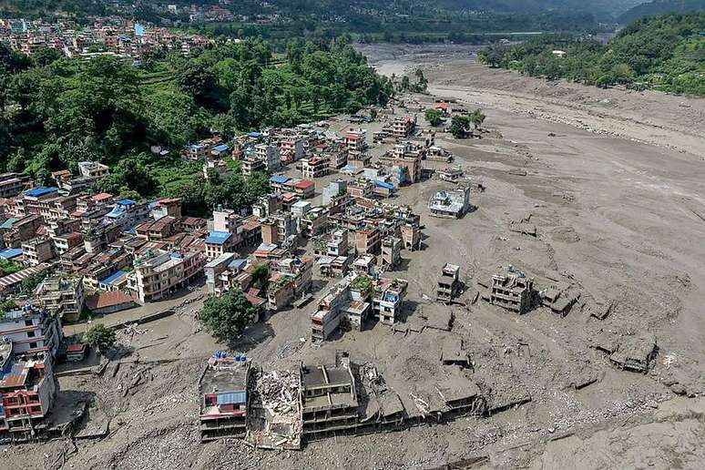 Casas encontram-se parcialmente submersas em &aacute;guas barrentas &agrave; beira de um rio ap&oacute;s inunda&ccedil;&otilde;es repentinas em Trishuli Bazar, no distrito de Nuwakot, no Nepal