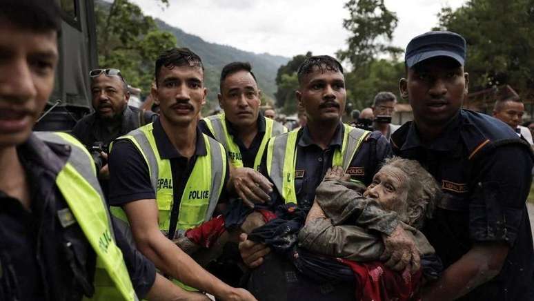 Policiais transportam uma idosa que sobreviveu &agrave; enchente repentina em Trishuli, no distrito de Nuwakot, no Nepal.