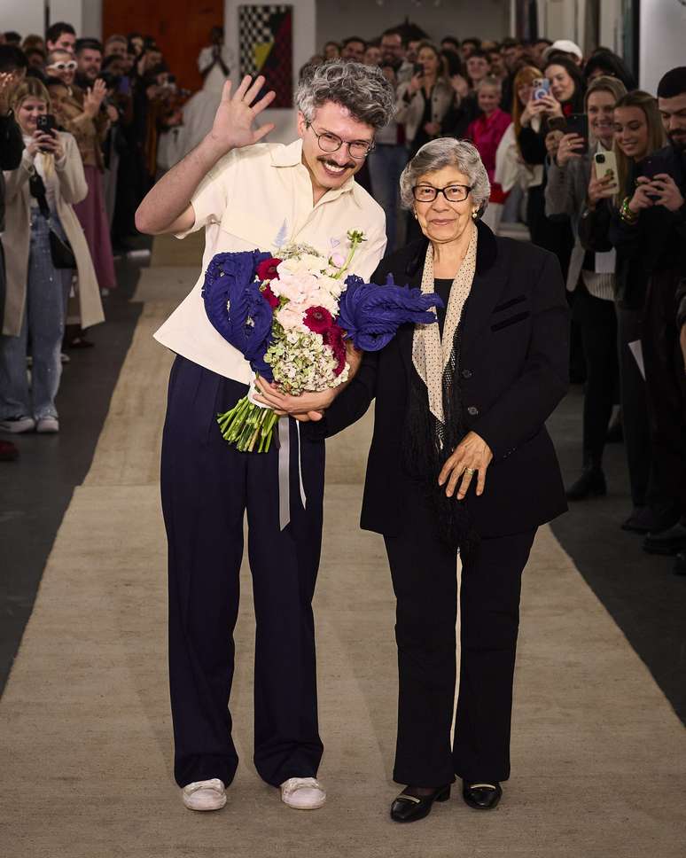 Augusto Paz e Tia Cleusa, no final do desfile de 2025, com a camisa que teve muita demanda dos clientes 