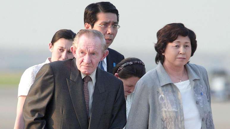O ex-sargento do Ex&eacute;rcito dos EUA, Charles Robert Jenkins, chega ao Aeroporto de Haneda, em T&oacute;quio, em 18 de julho de 2004, acompanhado da esposa e das filhas