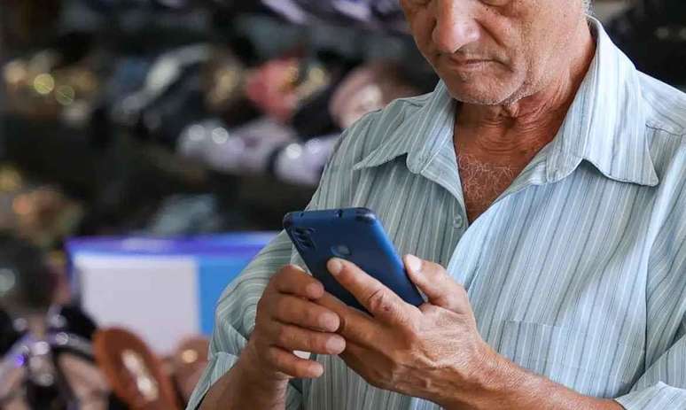 homem idoso mexendo em celular