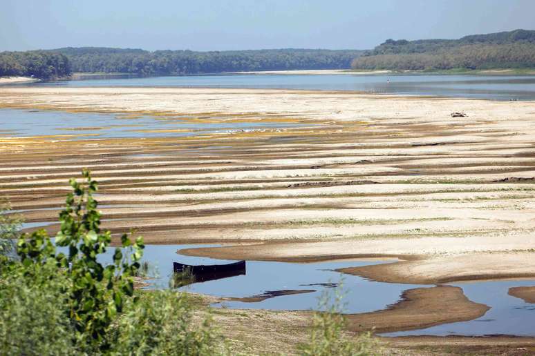 bancos de areia e baixo n&iacute;vel do rio, barco vazio em primeiro plano.
