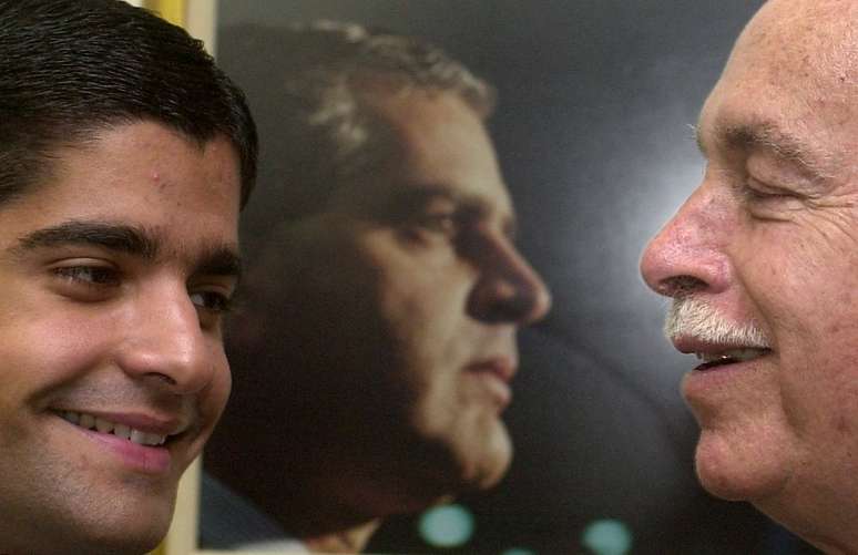 ACM sorri para seu neto ACM Neto no gabinete do tamb&eacute;m senador ACM Filho, em 2002. Ao fundo, foto de Ant&ocirc;nio Carlos Magalh&atilde;es Filho