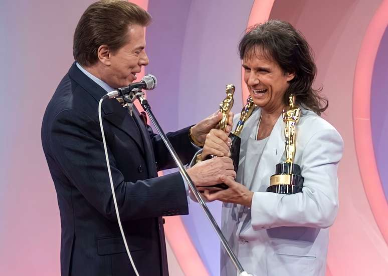 O cantor precisou equilibrar as estatuetas do Trof&eacute;u Imprensa entregues por Silvio Santos