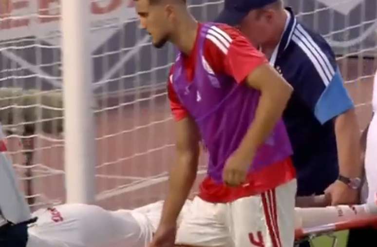 El Kaabi, do Olympiacos, recebe o aux&iacute;lio de um colega de time ao deixar o campo na maca &ndash;