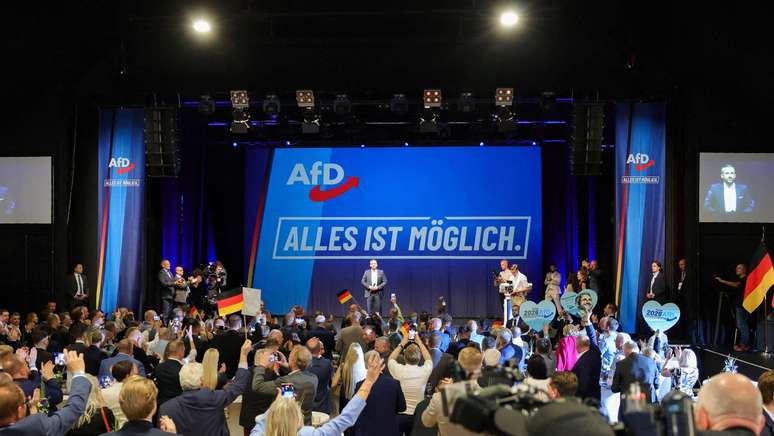 Multid&otilde;es agitavam bandeiras alem&atilde;s na festa de comemora&ccedil;&atilde;o da elei&ccedil;&atilde;o ap&oacute;s o fechamento das urnas. No fundo, o lema da AfD: "tudo &eacute; poss&iacute;vel"
