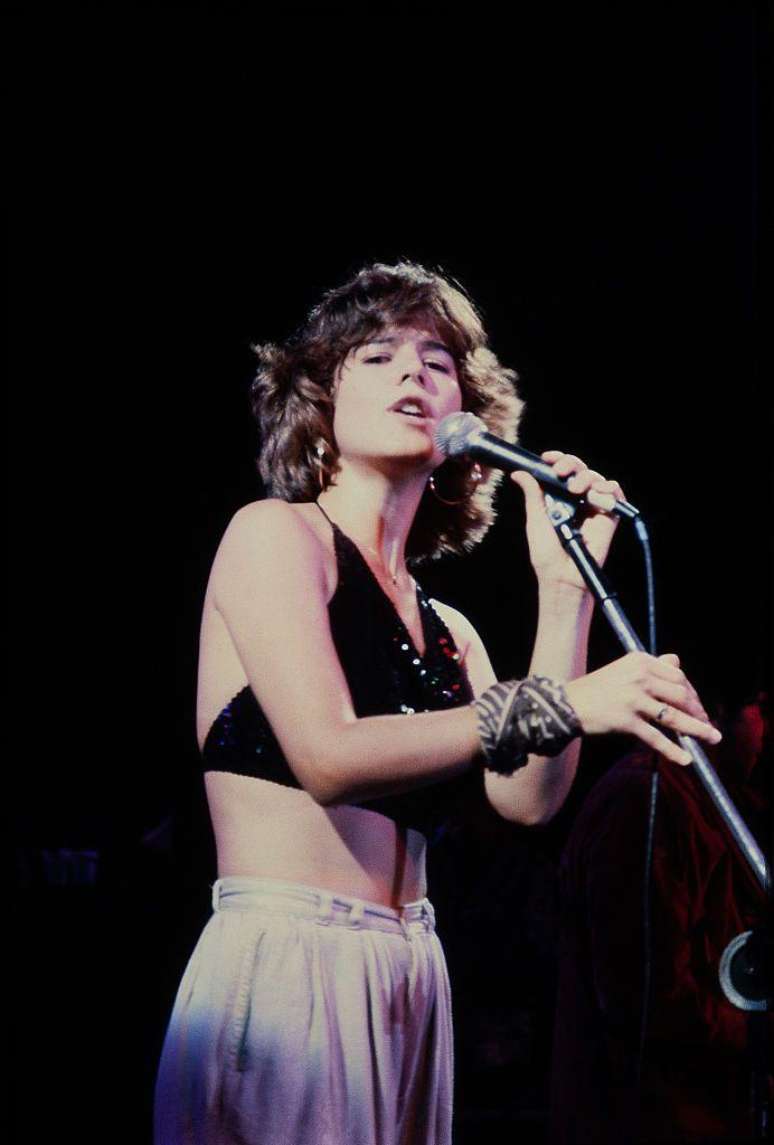 Paula Toller, que foi vocalista do Kid Abelha, veste top preto cheio de brilho em show nos anos 1980