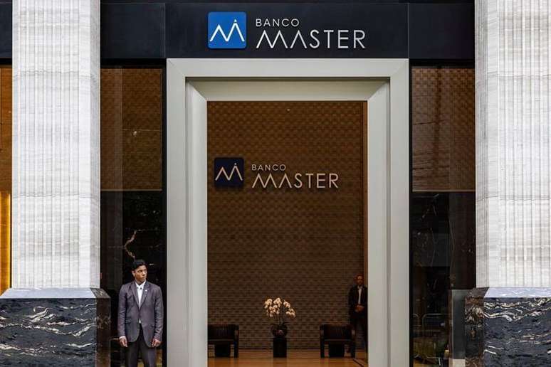 Seguran&ccedil;a em frente a portal de entrada com logo do Banco Master