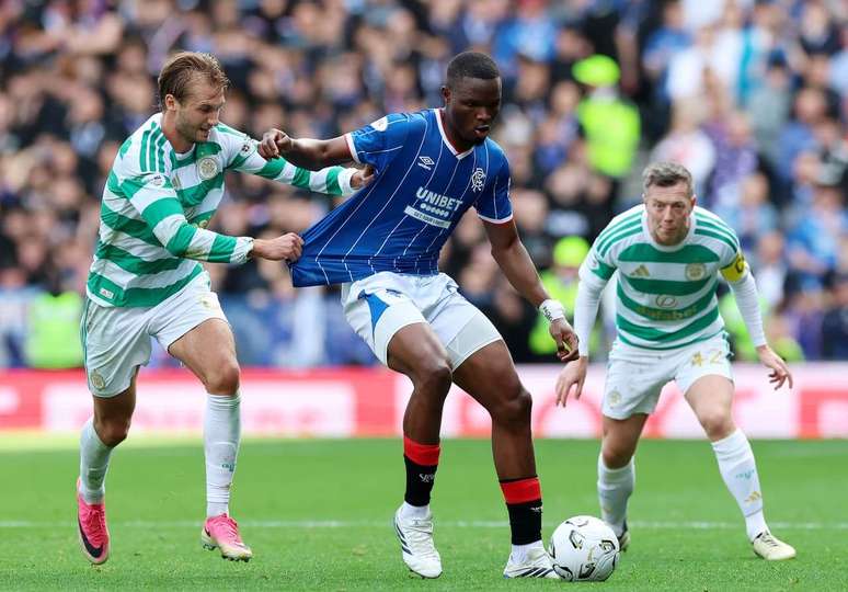 Makhanya (de azul, no centro) desarma o ataque do Celtic, sai com a bola e inicia a jogada do&nbsp; Rangers.&nbsp;