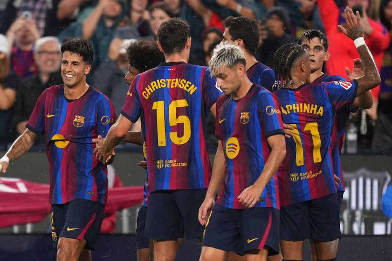 Raphinha, &agrave; direita, celebra com os companheiros o seu primeiro gol na goleada do Barcelona sobre o Santander.&nbsp;