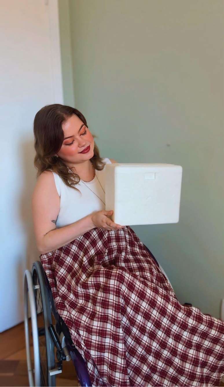 Maria Paula segurando a primeira caixa com medicamentos para o tratamento