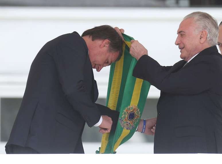 Jair Bolsonaro recebe a faixa de Michel Temer durante a cerim&ocirc;nia de posse presidencial em 2019.