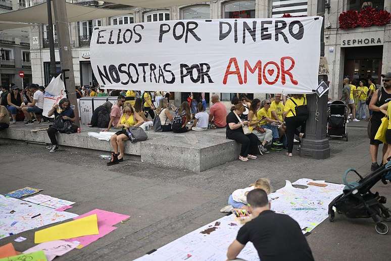 Faixa com os dizeres 'eles por dinheiro, n&oacute;s por amor'