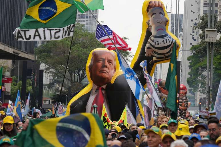 Apoiadores de Fl&aacute;vio Bolsonaro seguram infl&aacute;vel de Donald Trump durante com&iacute;cio de 7 de Setembro em S&atilde;o Paulo.