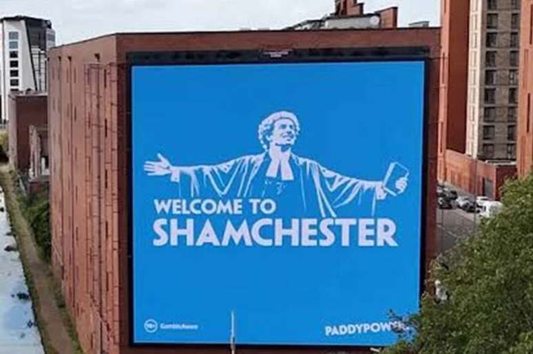 Cartaz em um pr&eacute;dio de Manchester fazendo trocadilho com a palavra &lsquo;shame&rsquo; (vergonha em ingl&ecirc;s) &ndash;
