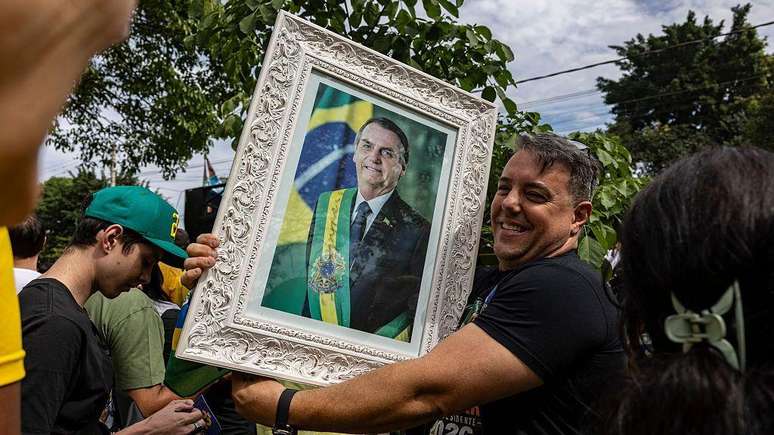 Eleitor com um quadro com um retrato de Jair Bolsonaro. 
