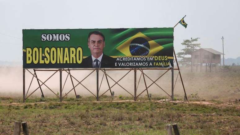 Um outdoor de Jair Bolsonaro fincado em uma paisagem &aacute;rida. 