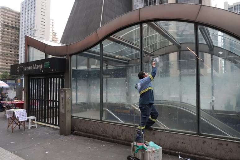Funcion&aacute;rio do Metr&ocirc; limpa vidro de um dos acessos &agrave; esta&ccedil;&atilde;o Trianon-Masp na Avenida Paulista