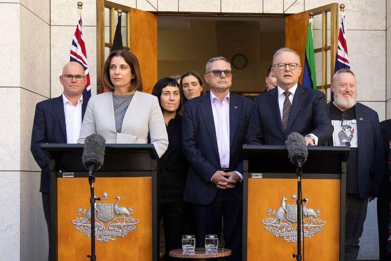 A ministra das Comunica&ccedil;&otilde;es da Austr&aacute;lia, Anika Wells (p&oacute;dio &agrave; esquerda), e o primeiro-ministro do pa&iacute;s, Anthony Albanese (p&oacute;dio &agrave; direita) anunciam o projeto de lei Obriga&ccedil;&atilde;o de Assist&ecirc;ncia Digital