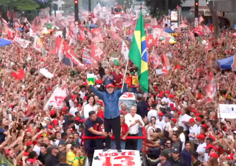 Lula sobe no cap&ocirc; do carro e segura bandeira do Brasil e exemplar da Constitui&ccedil;&atilde;o em SP