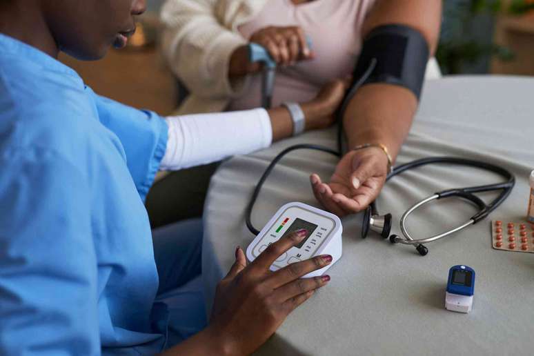 M&eacute;dico medindo a press&atilde;o arterial de um paciente