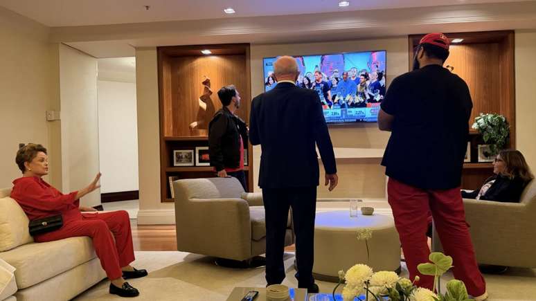 Lula (ao centro, de costas) assistindo &agrave; CNN Brasil na apura&ccedil;&atilde;o do 1&ordm; turno
