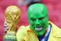 Torcedor brasileiro fantasiado de Máscara com a taça da Copa do Mundo em mãos na partida contra a Bélgica