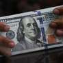 Um funcionário segura notas de dólar americano em uma casa de câmbio em Jacarta, na Indonésia (REUTERS/Willy Kurniawan) Foto: Reuters