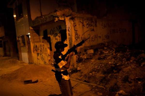 Había mucho movimiento en la favela de Mandela una noche reciente. A la luz de un farol, los clientes elegían de entre varios paquetitos de cocaína en polvo y marihuana que costaban 5, 10 y 25 dólares. Adolescentes con armas semiautomáticas recibían el dinero mientras coqueteaban con muchachas que lucían ropa provocativa, con el ombligo al aire.